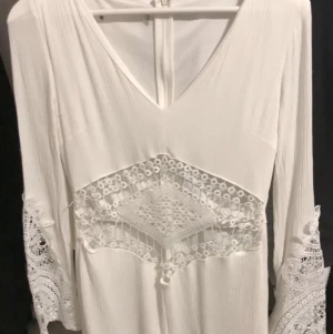 Vit Byxdress  - Säljer min vita byxdress från Nelly, storleken är xs men passar även s och m då den är ”luftig” genomskinlig mage med spets vilket är super snyggt den har dessutom en dragkedja på ryggen som inte syns för att kunna sätta på sig den. Använd 1 gång, nypris ~350