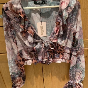 Topp - Blommig och leopardmönstrad blus i storlek 38. Aldrig använd med prislappen kvar. Nypris: 410kr