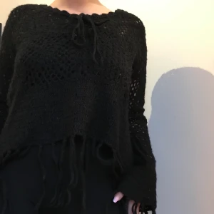 Svart stickadtröja med fransar  - Svart stickad tröja som tyvärr inte kommer till användning längre. Fina fransar i muddarna. Lite kortare i magen. Skriv till mig för fler bilder 