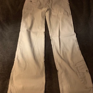 Utsvänga byxor med fickor. Str 25 - Vita bootcut byxor. Stretchigt material. Kan passa både XS/S. 