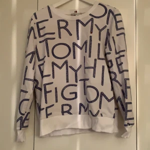 Tommy hilfiger sweatshirt  - Jättefin himfiger sweatshirt med blåa flätade marinen spirerade tryck där det står ”Tommy hilfiger” över hela tröjan. Strl S men lite större passar mig som vanligtvis har M i tröjor. Använd få tal gånger.