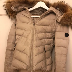  - Jacka från Hollies, stolek 38. Färgen beige/vit. Behövs en tvätt & samt saken man drar i på dragkedjan saknas. 