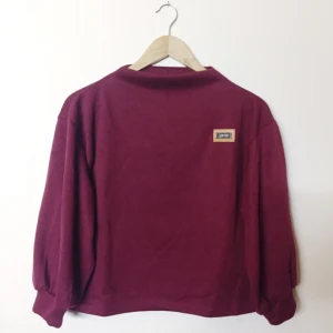  - Oanvänd tjocktröja i one size. Skönt material och fin vinröd färg. Köparen står för frakt, kan mötas upp i Uppsala.