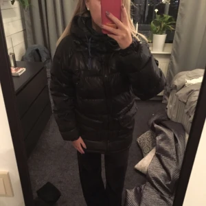  - En dunjacka som aldrig är använd.  Svart  