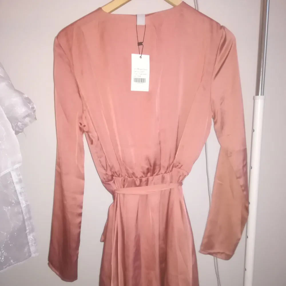 En rosa satin klänning från Nelly.com  Den är helt oanvänd och Prislappen sitter kvar.  Har du några frågor eller vill se mer bilder så är det bara att fråga. Klänningar.