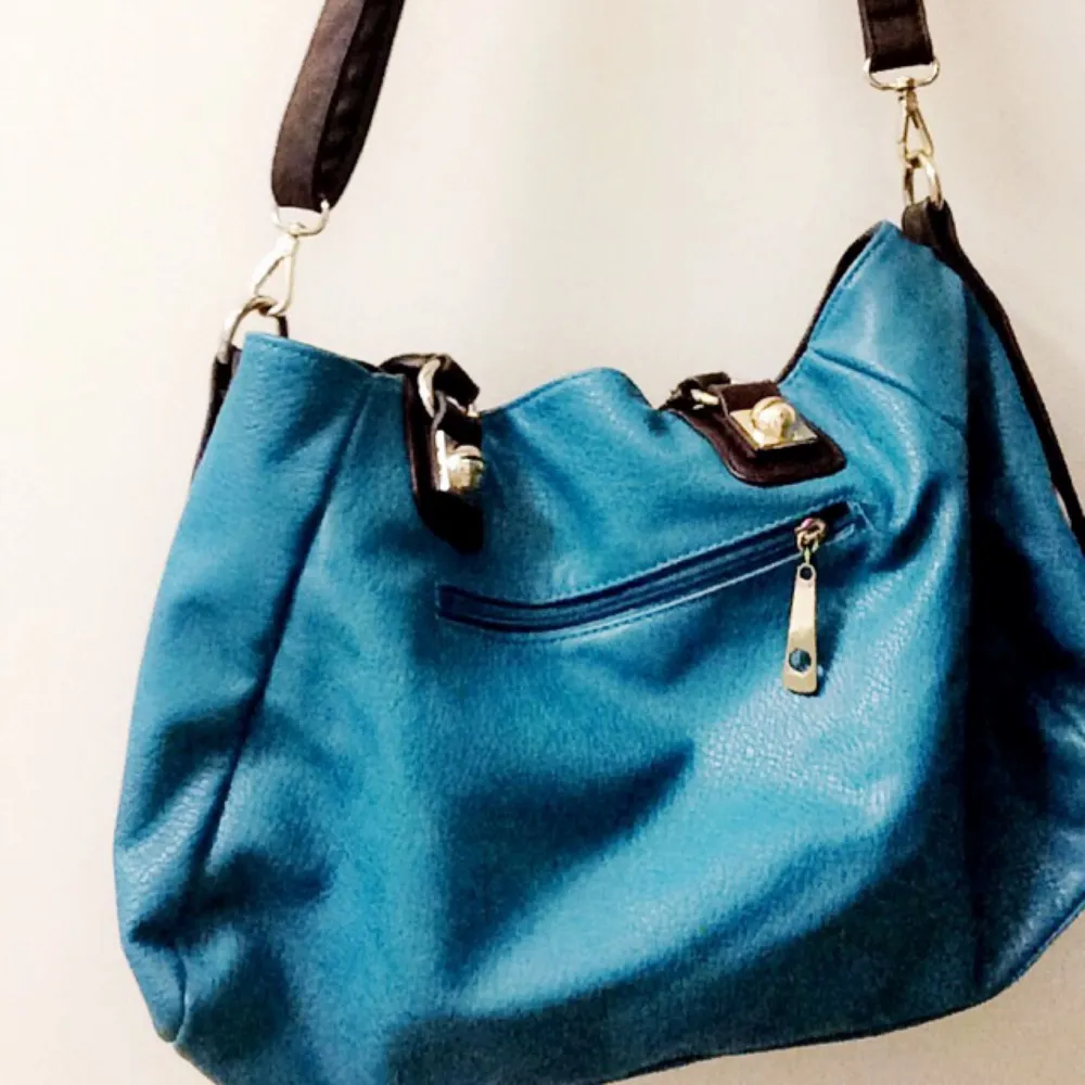 Blue tote bag with brown shoulder strap. . Väskor.