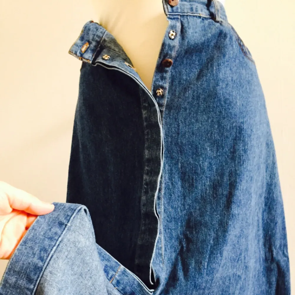 Långkjol i jeans med knappar längs hela framsidan. Riktigt fin med sina detaljer, (se bild). Märkt storlek 40, men har själv använd den som oversize. . Kjolar.