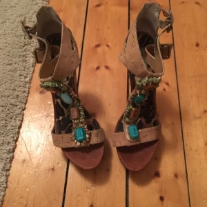  - Skor från Steve Madden i storlek 40 med läckra detaljer. En av stenarna är utbytt och har en annan ljusare nyans. Småstenarna runt den nedersta stenen har lossnat på den ena skon.