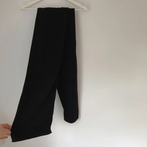  - Svarta byxor i vidare modell. Långa, ner lite över fötterna. Resår i midjan så passar de flesta storlekar :)