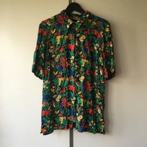  - Blommig blus från secondhand! En sommarfavorit! Funkar på S och M! Men även för XS beroende på hur man vill att passformen ska va! Slappt vid knapparna pga så är modellen! Köparen står för frakten! Betalningen sker via swish!
