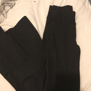 Svarta utsvängda byxor - Ett par svarta byxor som är högmidjade. Jätte sköna och stretchiga men som tyvärr blivit förkorta ( jag är 165 ) . Dom är lite utsvängda nere i benen och i bra skick. Ni står för frakt 