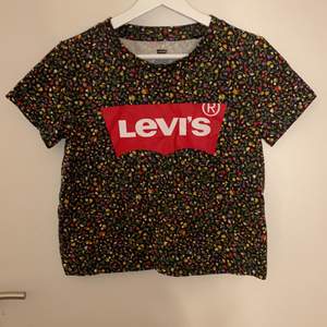 En jättesöt croppad t-shirt från levi’s med fint blommigt mönster på, den är knappt använd så den är i bra skick