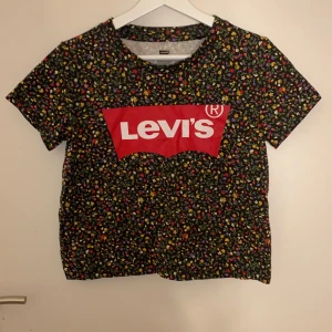 Levi’s t-shirt  - En jättesöt croppad t-shirt från levi’s med fint blommigt mönster på, den är knappt använd så den är i bra skick