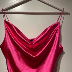 Rosa satin klänning - En superfin klänning från Hm som är i ett skönt stretchigt material. Drawstrings i sidan av klänningen. Aldrig använd. Frakt 40 kr 