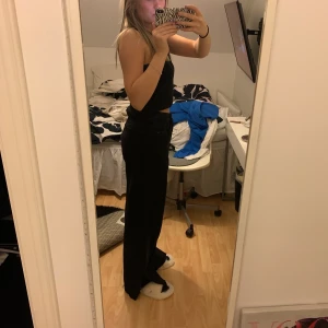 Raka svarta jeans - Svarta långa jeans, använda 3 gånger, säljer pågrund av att de har blivit för stora för mig. Slitsen vid foten har jag gjort själv. Är 1.66 och de är alldeles för långa för mig. Köpare står för eventuell frakt