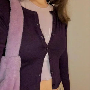 Croppad mörklila kofta - Säljer denna thrifted kofta! Super fin att göra outfits med! STRL XS MEN ÄR MER SOM S OCH PASSAR MIG SOM HAR S/M. Helt oanvänd och känns väldigt ny och fräsch eftersom original prislappen satt kvar när jag köpte den. 