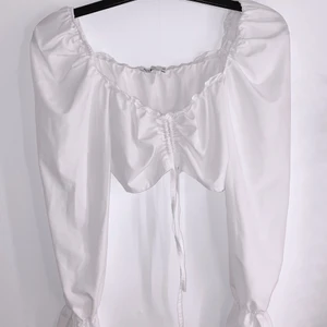 Vit topp från nelly - En vit topp från Nelly med lite större axelmuddar. Super söt och endast använd en gång