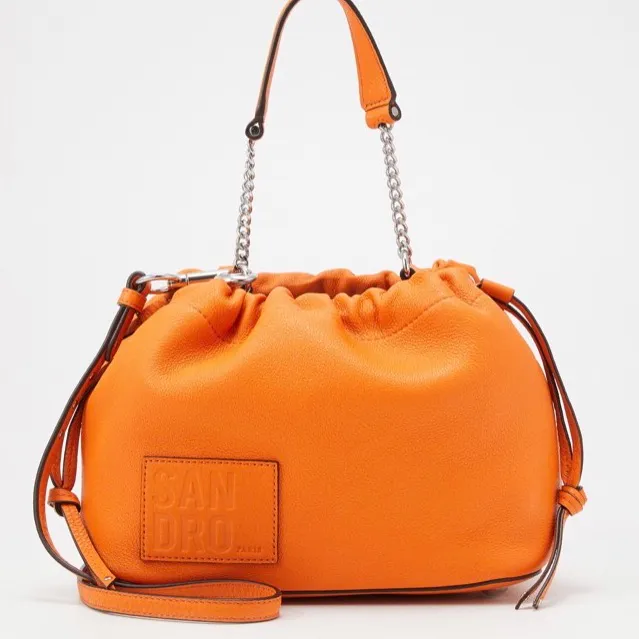 Snygg orange väska från sandro. Sparsamt använd. Har gjort två hål i det långa väskbandet för att kunna ha den kortare. Väskor.