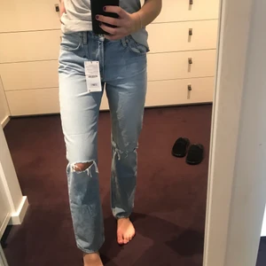 Lågmidjade jeans med hål - Ett par assnygga helt oanvända mid-waisted/lågmidjade jeans med slitningar från zara, som jag säljer för att jag råkade köpa två par likadana. Jag är 174 cm lång och dom sitter som på bilden. Dom är i storlek 38 men passar även mig som brukar ha 36, fast då sitter dom lite lösare. Jag köpte dom för nästan 400kr från zaras hemsida för ganska längesen.