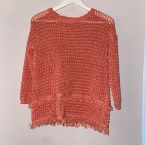 En stickad mysig tröja till salu - Färg: coral (rosa/orange). Tröjan är i en super skick (oanvänd)