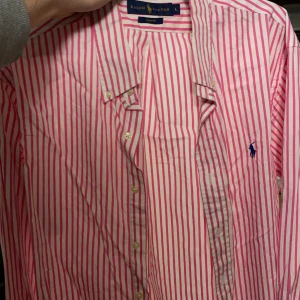 Ralp Lauren skjorta vit/rosa - Polo Ralp Lauren skjorta i stl L, slimfit. Knappt använd. Plagget är nyskick och är endast någon månad gammal. 