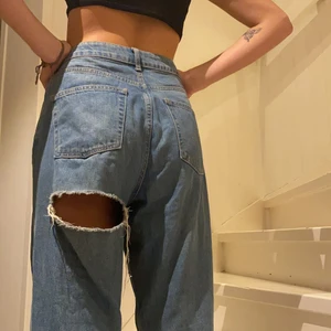 Mom-jeans med slitning under rumpan  - Skitballa jeans med slitning/hål under rumpan. Mom-jeans, ganska losefit. Storleken är W/30 L/32, hon på bilden bär vanligtvis W/27 L/30 🌼  Köparen står för frakten men jag kan även mötas upp i närheten 💚