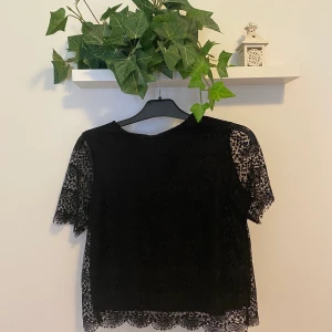 Halvt Croppad svart t-shirt med spets - En svart t-shirt som är lite halvt croppad. Säljer den då den inte kommer till användning. Köparen står för frakt!!💗