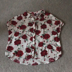 Blus med rosor från H&M - Blus med rosor från H&M i fint skick, köpare står för fraktkostnaden!