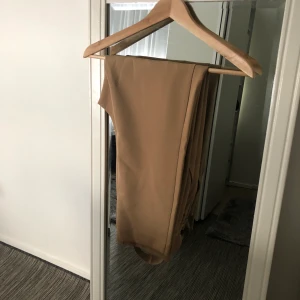 Beige kostymbyxor  - Beige kostymbyxor från asos i storlek 38 (M). Använt få gånger, men fortfarande i väldigt bra skick. Frakt förekommer, men kan även mötas i Göteborg. För fler frågor och bilder kontakta mig! 