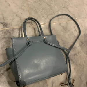 Zara väska - Ljusblå väska från Zara, finns medföljande långt axelband, aldrig använd