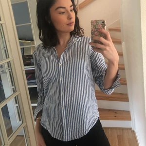 Randig skjorta - Blå/vit-randig skjorta i 100% ekologisk bomull från Gina tricot. Väldigt lätt och skön! Perfekt på en varm sommardag eller under en tjocktröja. Kan mötas i gbg eller skickas mot betald frakt 