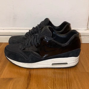 Nike Air Max 1 VT QS, storlek 37,5 - Storlek 37,5 • Nike Air Max 1 VT QS (black/white) • Sparsamt använda • Pris 250 kr • Får gärna buda, prioriterar snabb affär • Kan mötas upp i Stockholm eller frakta, köparen betalar frakt!