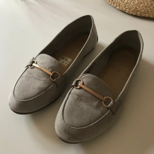 Loafers i storlek 38 - Ljusgrå loafers i storlek 38. Använder inte pga. inte min färg. Finns ett litet märke frampå skon, därav priset.