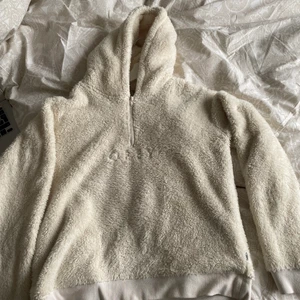 Obey teddy hoodie - mysig hoodie från obey, ser gul ut på första bilden men är krämvit (sista bilden) strl M men är liten i strl så sitter som en S. Slutsåld överallt så passa på😉