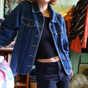 Jeansjacka - Skön jeansjacka med härliga knappdetaljer. Snygga vita sömmar som ger en najs kontrast till det lite mörkare jeanstyget. M typ. Köpte i London.