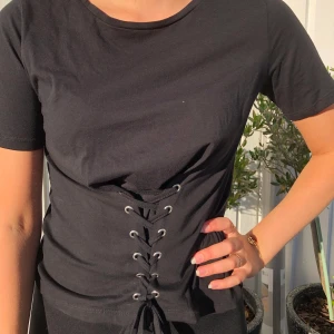 Svart korsett t-shirt - T-shirt med korsett från Only. 30kr+ frakt, först i kvarn eller högsta bud. 