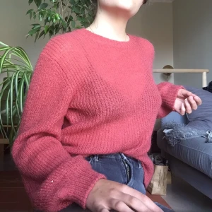 Stickad tröja m ballongärm Weekday strl S - Tröjan går i en varm rosa ton, ribbstickad med fin och tunt gran vilket gör tröjan skir och luftig. Material: 43% mohair, 33% polyamid, 24% akryl