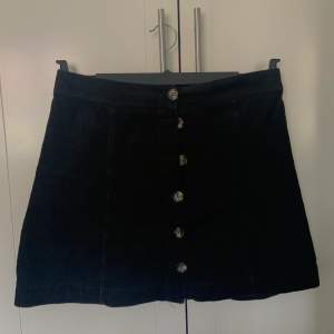 Svart Manchester kjol med knappar hela vägen från H&M. Storlek 40. 60kr + frakt