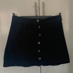 Kjol - Svart Manchester kjol med knappar hela vägen från H&M. Storlek 40. 60kr + frakt
