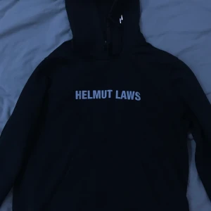 Helmut Lang Hoodie - Äkta Helmut Lang Hoodie svart med reflextext fram och tryck bak. Köpt för ca 3000 och säljer för 900(sänkt från.1700). Använd få gånger och är i väldigt bra skick. Skriv vid intresse och för mer info! PRIS KAN DISKUTERAS!