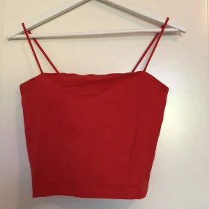 Röd topp från Ginatricot i strl M - Fin röd topp som går ovanför naveln. Toppen är i bra skicka och är från Ginatricot i strl M