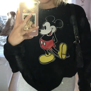 Svart Musse pigg sweatshirt - Super skön och supersnygg! Köptes på Disney land för dyra pengar men säljer för billigare SÅKLART! Har bara använt den få ggr. 