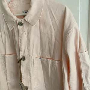 ROCK/KAPPA I DENIM - LEE X WEEKDAY - Ljusrosa denim rock/kappa från LEE X WEEKDAY. Använd en gång vid fotografering. Den har en fläck på ena axeln men har inte tvättat pga att prislapp sitter kvar. Nypris 1000 kr. Möts på Södermalm och vid frakt står köparen för kostnad!