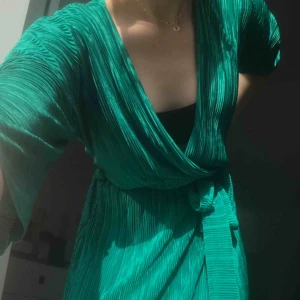  - Oanvänd klänning från Gina Tricot som når vaderna, plisserad!