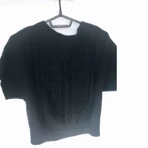 Stickad figurnära svart tröja från DKNY. Stickat mönster framtill. Fint skick. 