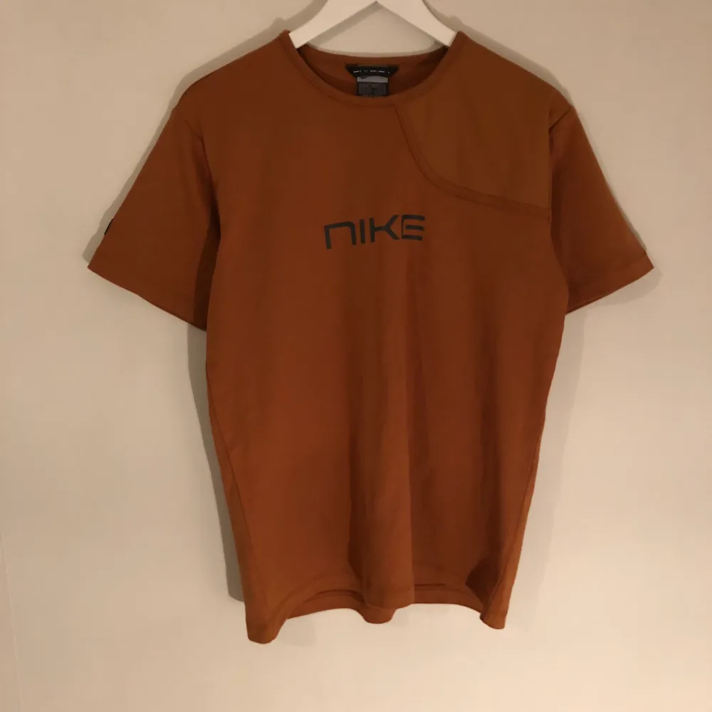En fin vintage Nike T-Shirt i brun färg. Tröjan är i mjuk kvalité och är ganska tjock. Tshirten har en liten bit med annat tyg som man kan se vid högra armen. Storlek medium.. T-shirts.
