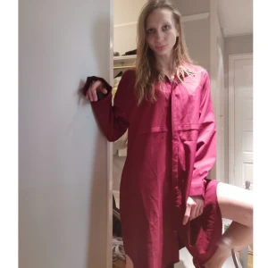 Boohoo vinröd klänning - Vinröd klänning i skjorta stil. Super fin och ledig stil! Måtten är: axlar 47cm, armslängd 62,5cm, byst 61cm och längd på 95cm.