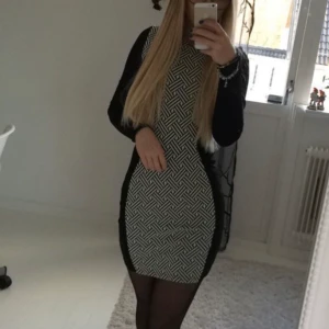 Svart och vit klänning  - En svart figursydd klänning med vita detaljer. Tyger är ganska så tjock och klänningen är väldigt stretchig. Endast använd ett par gånger. 