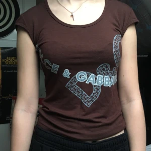 D&G topp - Topp från Dolce&Gabbana i fin brun nyans. Kan skicka fler bilder på passform men skulle säga att den passar allt från en XS till M. Budgivning i kommentarerna. Högsta bud: 130kr och avslutas 3/1