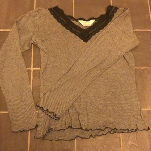 Randig långärmad  - Randig långärmad i svart och vitt. Mycket fin uringning i spets. Köpt second hand. 